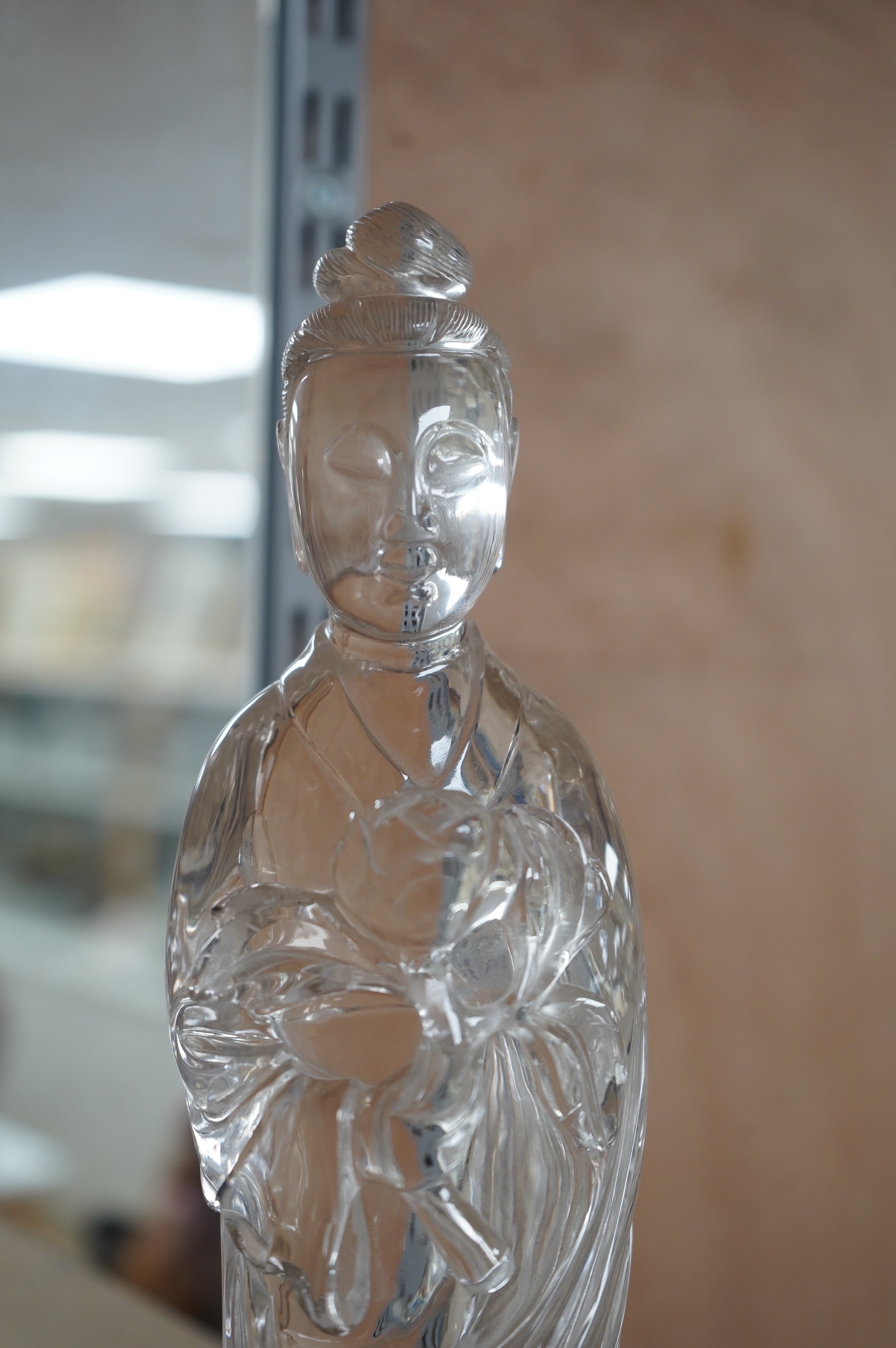 A large Chinese rock crystal figure of a standing lady holding a peony branch, 20th century, 27cm high. Condition - some chips to base